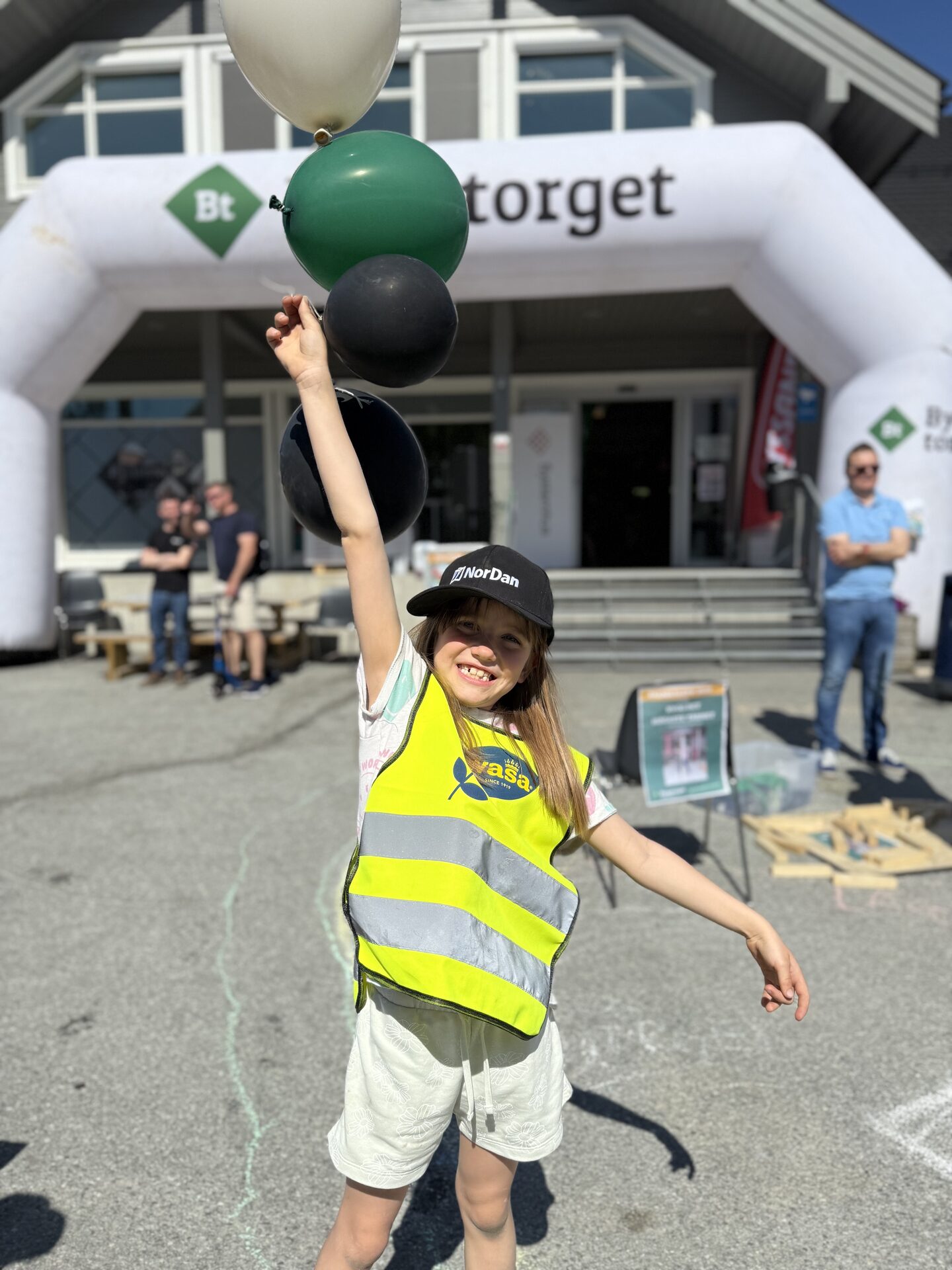 Jente med ballongar framfor Byggtorget